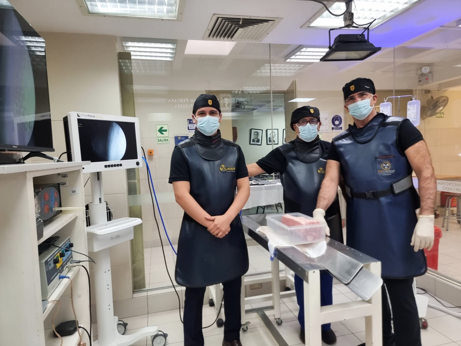 Tres profesionales con ropa quirúrgica en sala de operaciones